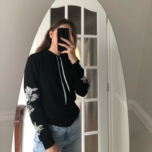 Black sweatshirt with flowers on sleeves